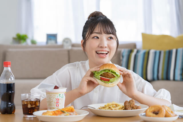 女性がハンバーガーを食べている様子