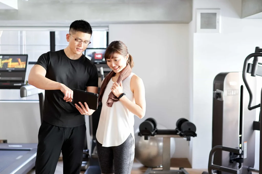 男性トレーナーと女性のお客様がカウンセリングしている様