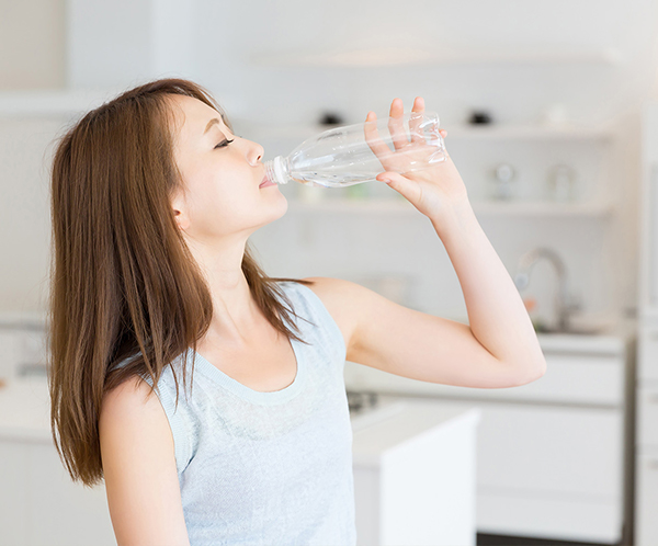女性が水を飲む姿