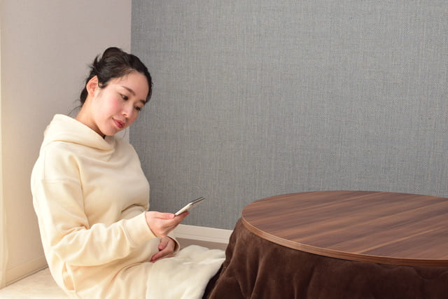 こたつに入って温まる女性