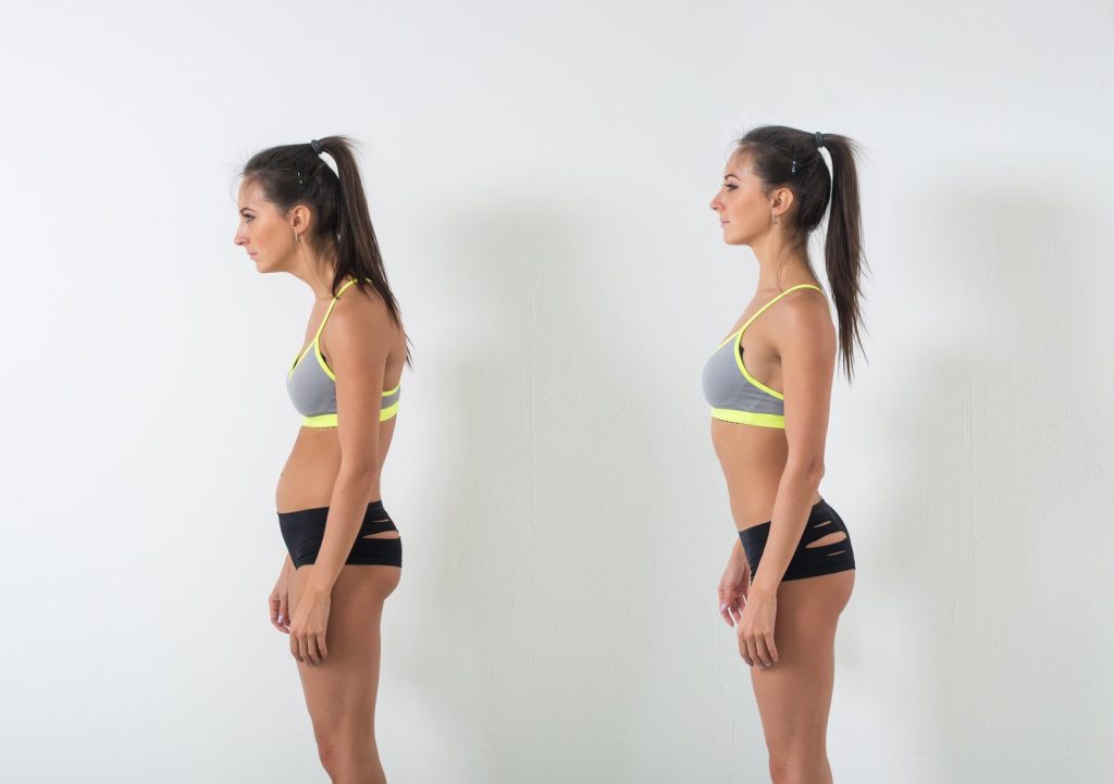 パーソナルジムで女性が正しい姿勢を意識して立っている様子。猫背・反り腰改善と下半身太り対策をイメージした写真。