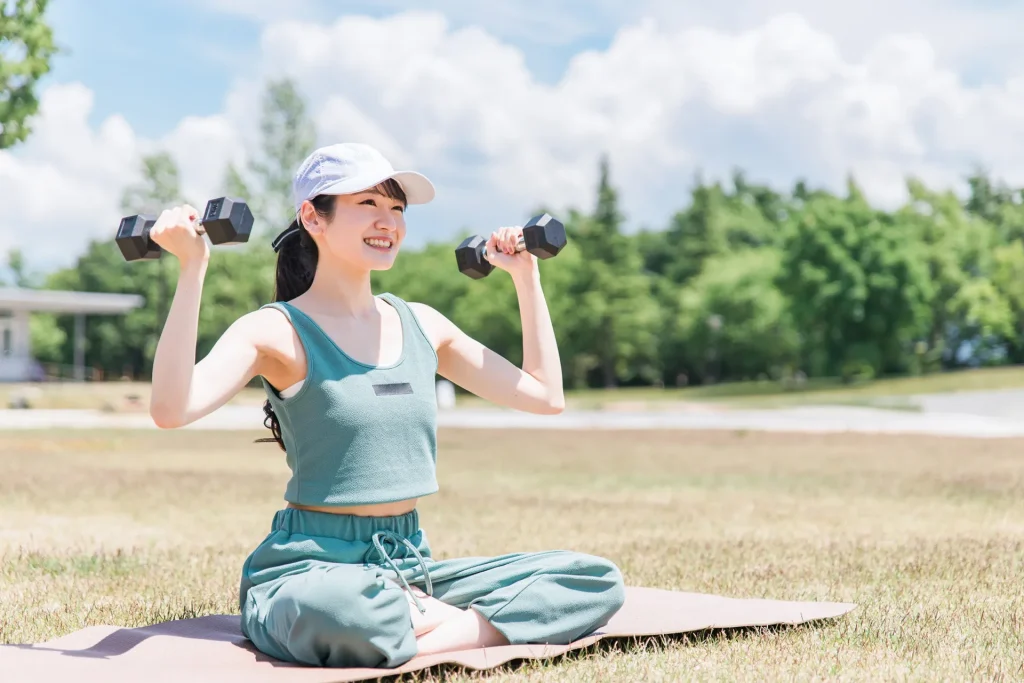 朝食を摂った後にダンベルを使って運動する女性。