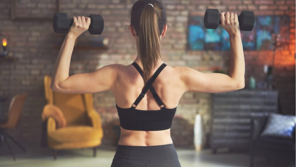 ダンベルを使って軽いトレーニングを行う女性の後ろ姿